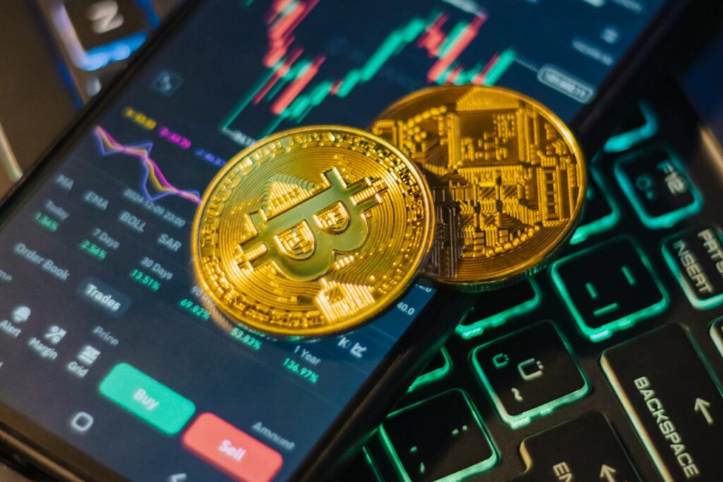 Dois bitcoins em cima de um celular.