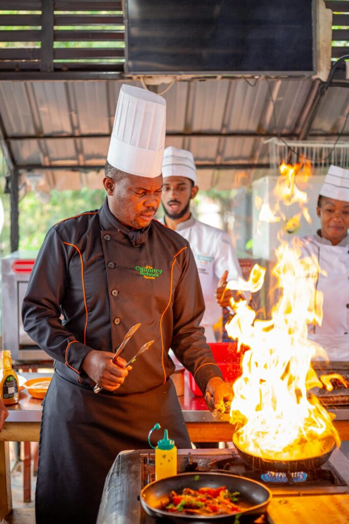Cozinheiro fritando algo no fogo alto.