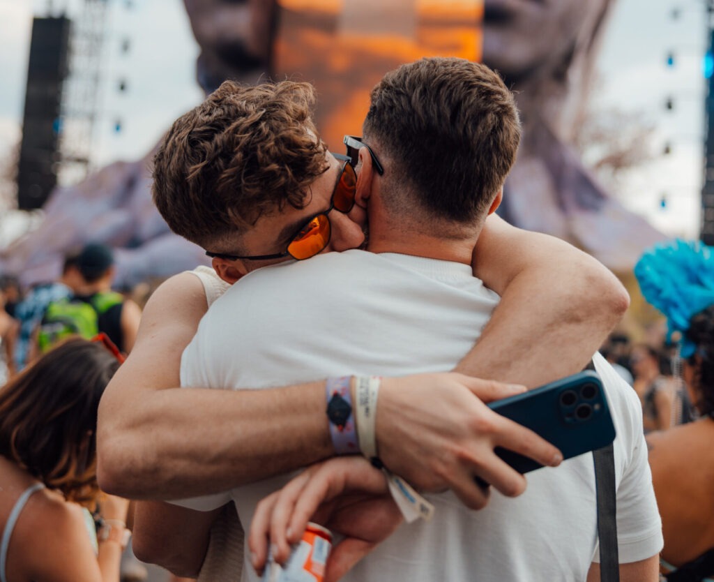 Dois amigos se abraçando em frente ao palco Core do Tomorrowland Brasil.