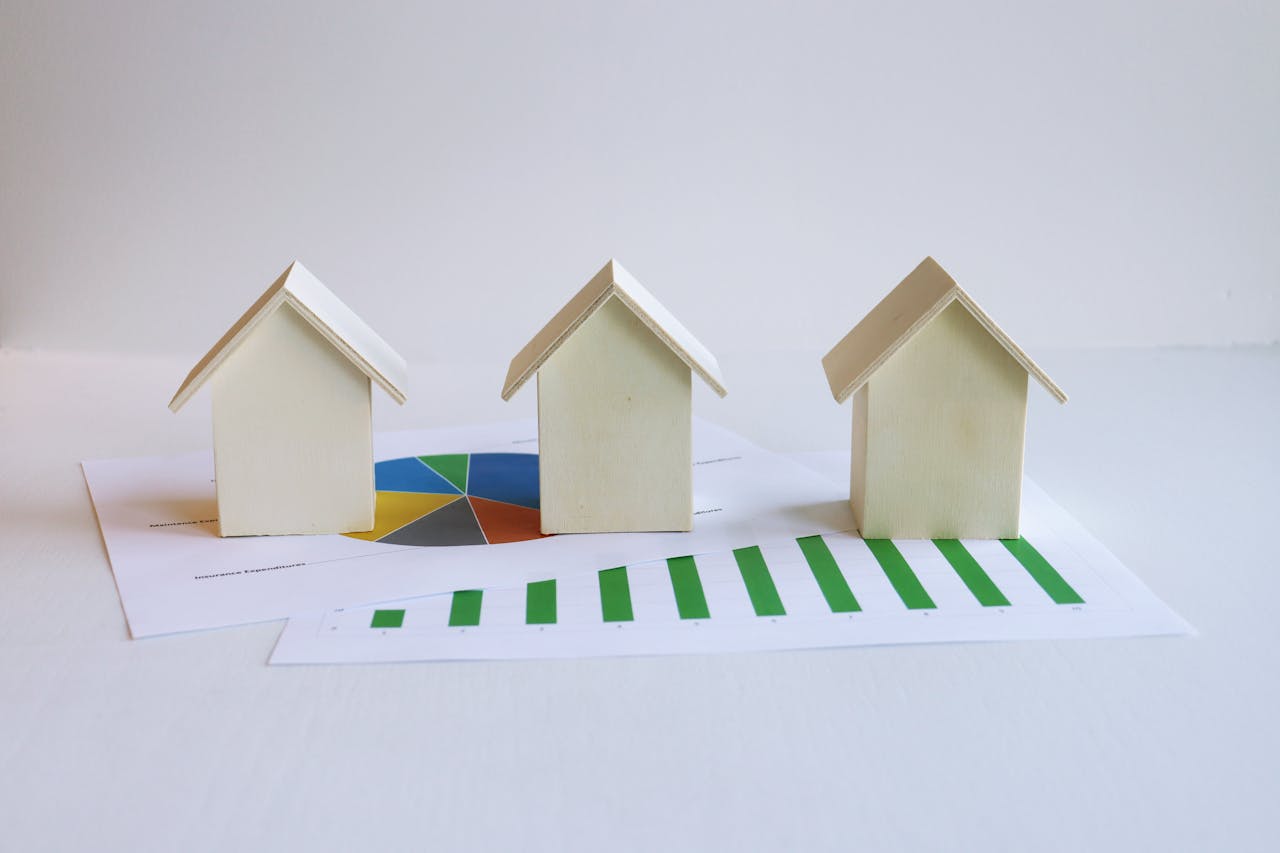 Casas modelo de madeira em gráficos retratam análise e tendências do mercado imobiliário.