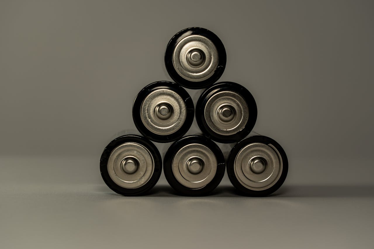 Pilhas AA metálicas empilhadas em formato de pirâmide, simbolizando poder e armazenamento de energia.