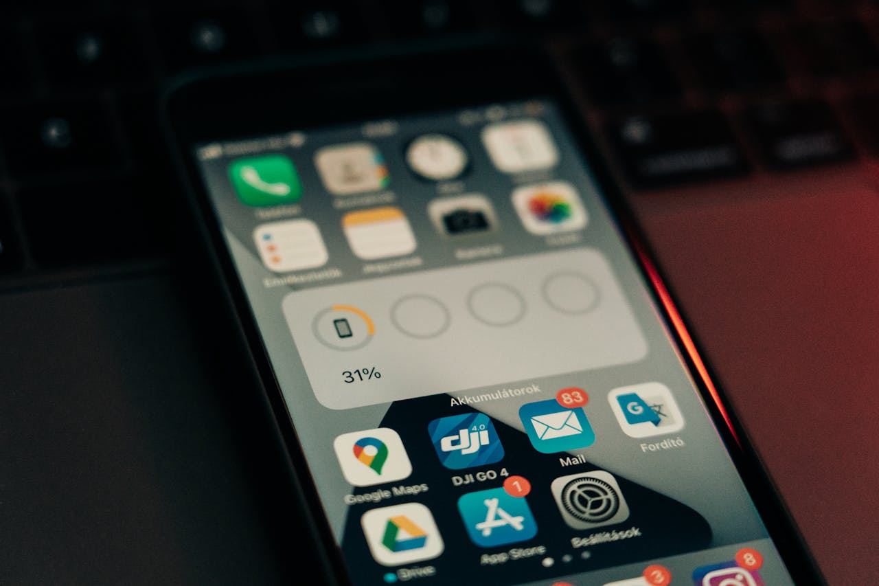 Um smartphone com vários aplicativos em sua tela colocado em um teclado, mostrando um nível de bateria de 31%.