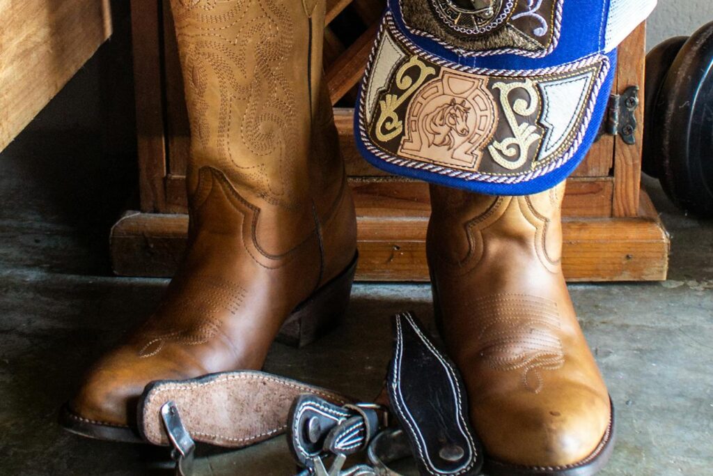 Par de botas, boné e cinta de cowboy.