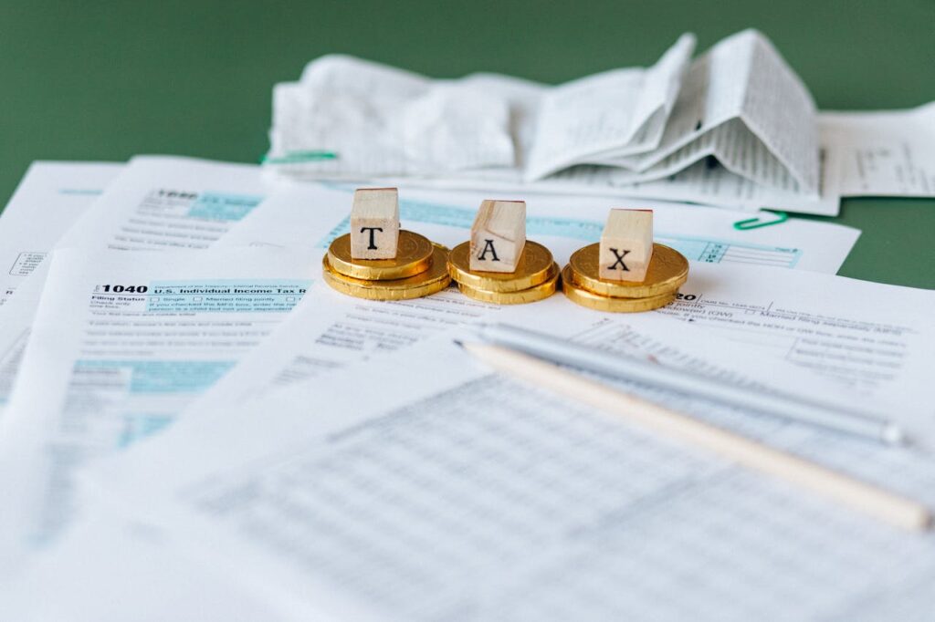 Cubos em cima de moedas formando a palavra "TAX"