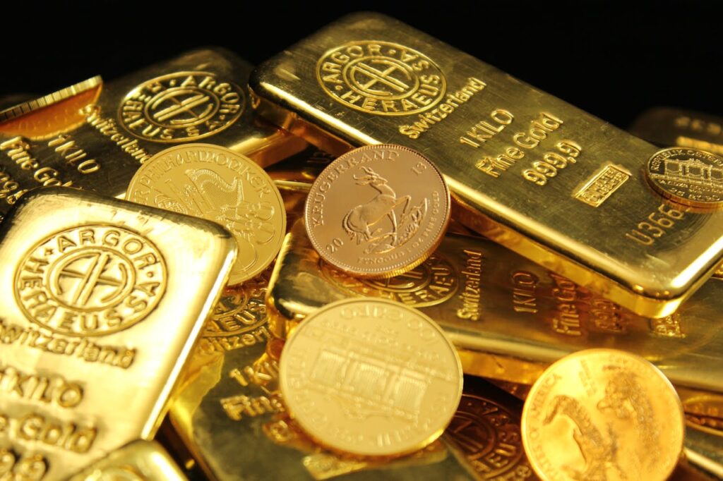 Barras e moedas de ouro amontoadas.